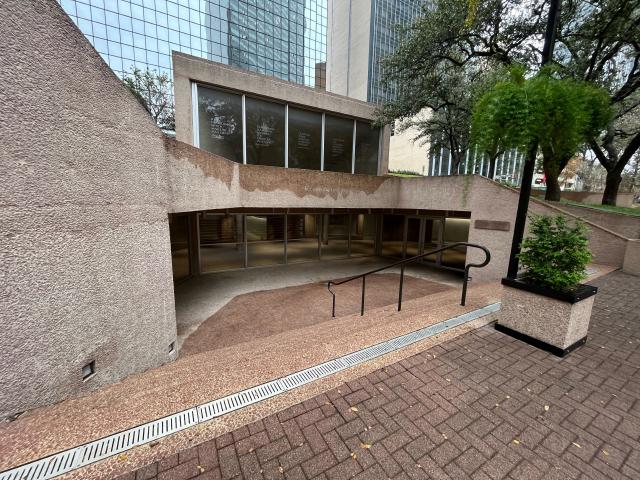 Stairs down to glass doors surrounded by concrete